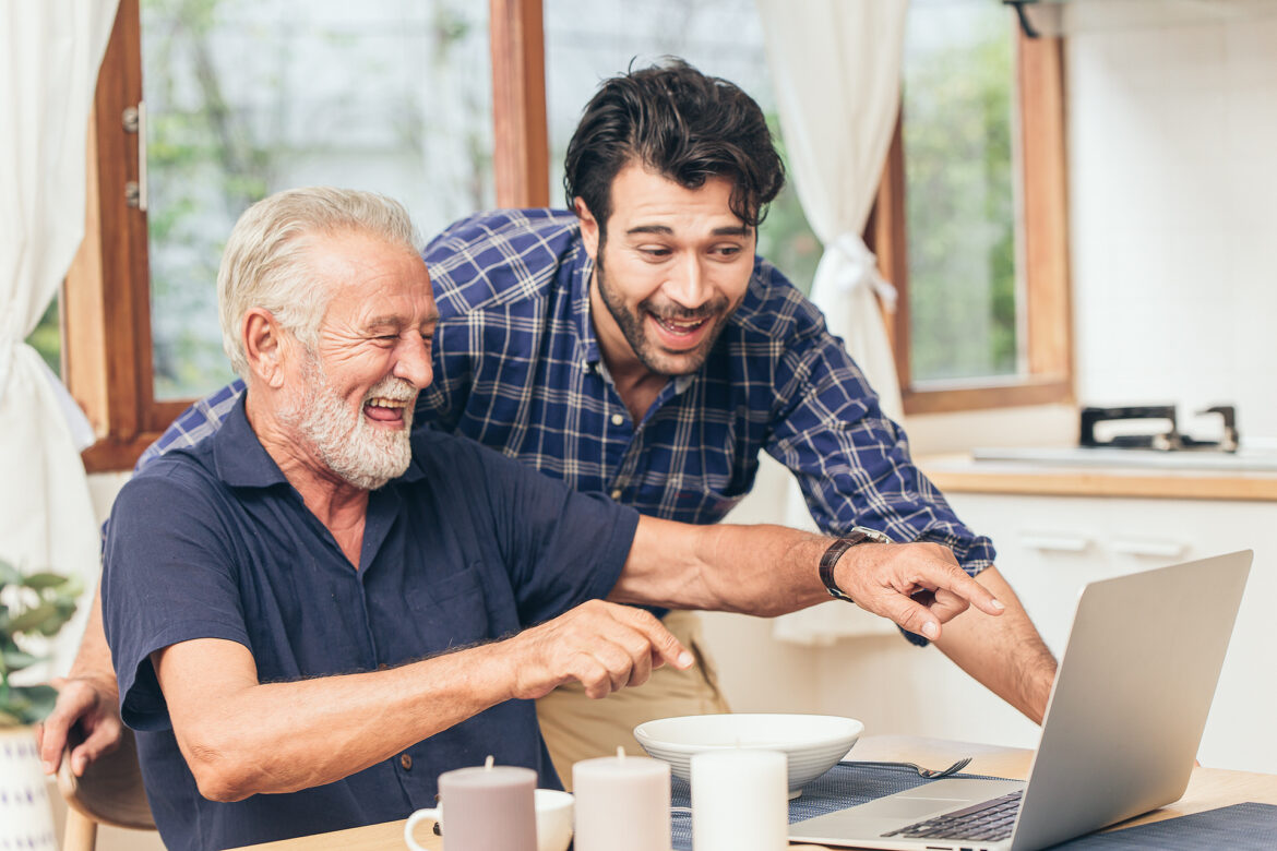 old man fun smile happy to looking at laptop with son. using communication technology for family happiness elder home care to connection other concept